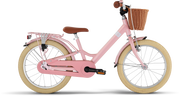 PUKY YOUKE CLASSIC 18 är en rosa barncykel med gräddfärgade däck, brun sadel och styre, flätad korg fram och pakethållare bak, mot en vit bakgrund.