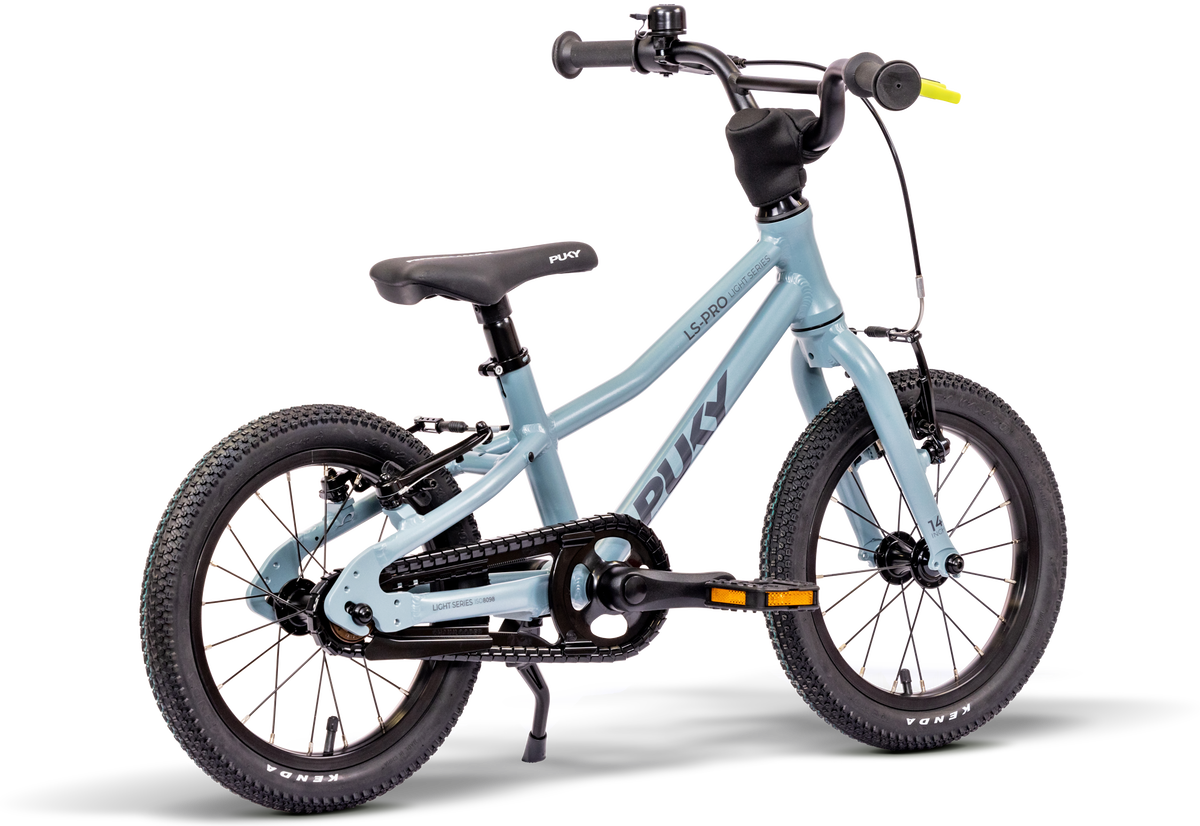 PUKY LS-PRO 14 är en ljusblå barncykel med en lätt aluminiumram, svarta däck, sadel och styre samt kedjeskydd, som visas från sidan mot en vit bakgrund.