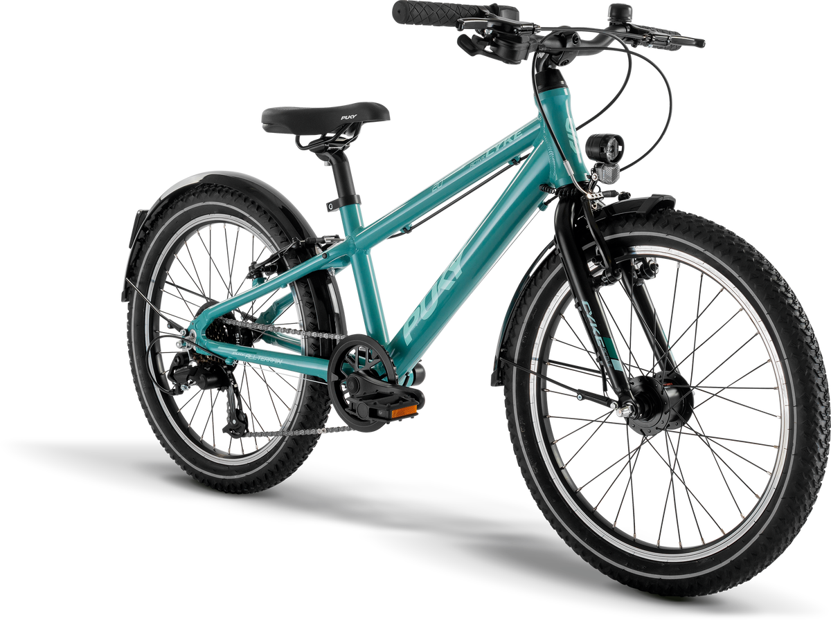 PUKY CYKE 20-7 ACTIVE är en blågrön mountainbike för ungdomar med svart styre, sadel, pedaler och däck, samt fram- och bakskärmar, ett stödben och en strålkastare, mot en vit bakgrund.