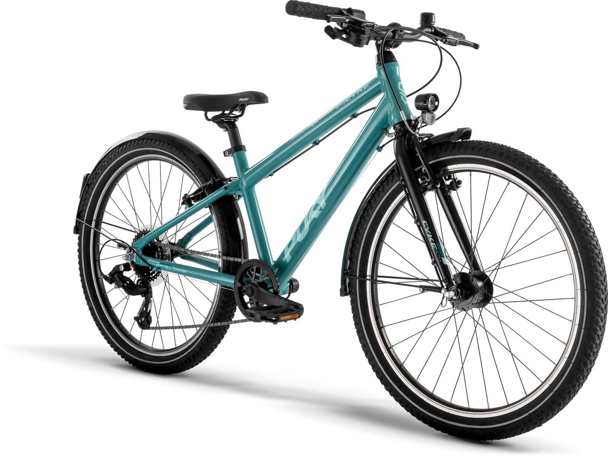 PUKY CYKE 24-8 ACTIVE är en blågrön mountainbike med svart styre, sadel och däck, som visas vinklad mot en vit bakgrund. Den har framfjädring, bakväxel och hjulreflektorer.
