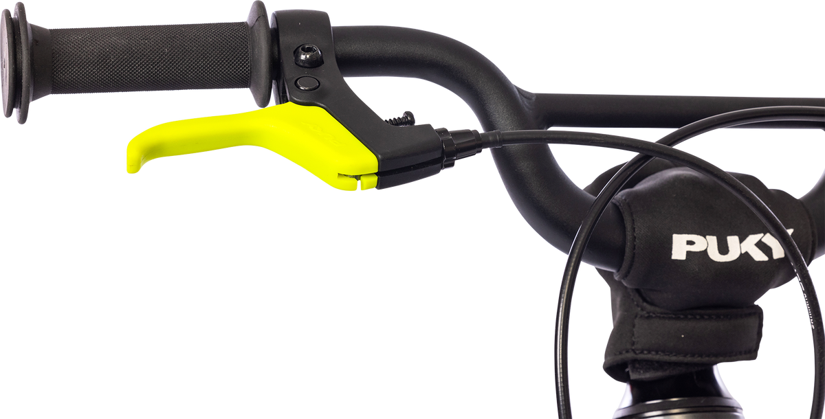 Närbild av cykelstyret PUKY LS PRO 16-2 FLOWMATIC med svart grepp, vadderat "PUKY"-fäste, ljusgul bromsspak och flera kablar som löper längs styret.
