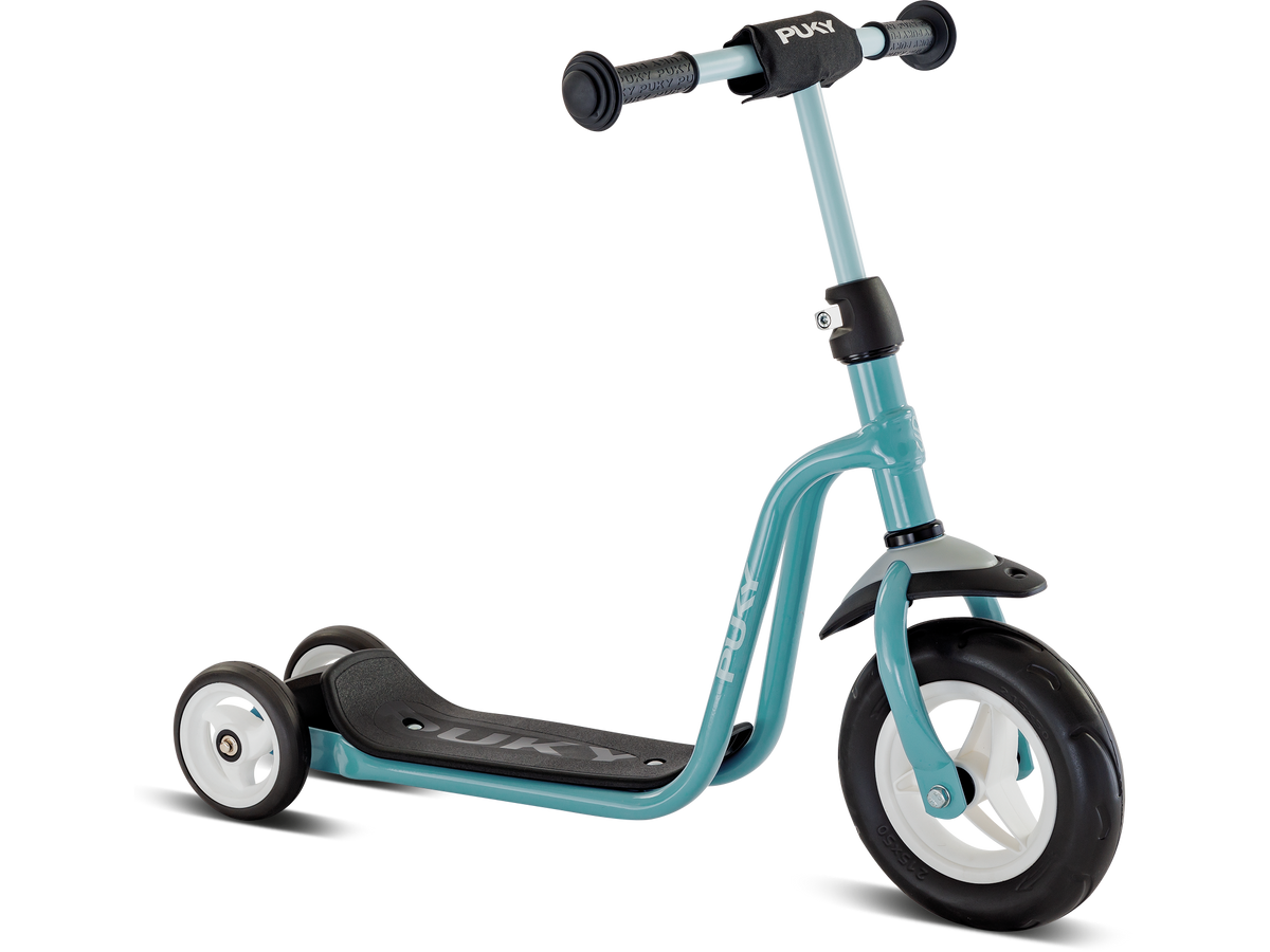 PUKY R1 är en blågrön och svart trehjulig sparkcykel för barn med vita hjul, svart styre och svart fotplatta, mot en vit bakgrund.