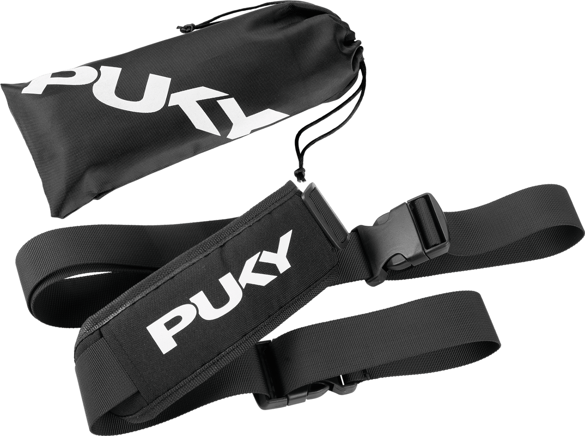 PUKY Tragegurt BUDDY är en svart justerbar bärrem med en vadderad del och vitt "PUKY"-märke, som visas bredvid en matchande svart förvaringsväska med dragsko, även den med "PUKY"-logotypen.